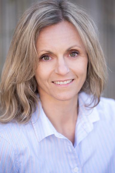 A woman looking at the camera with a blue shirt on