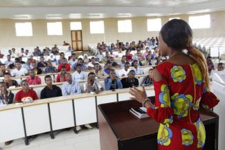 Female lecturer in foreground lectures a room of students