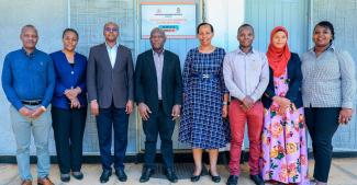 Tanzanian lecturers standing and smiling into the camera at the opening of their new centre